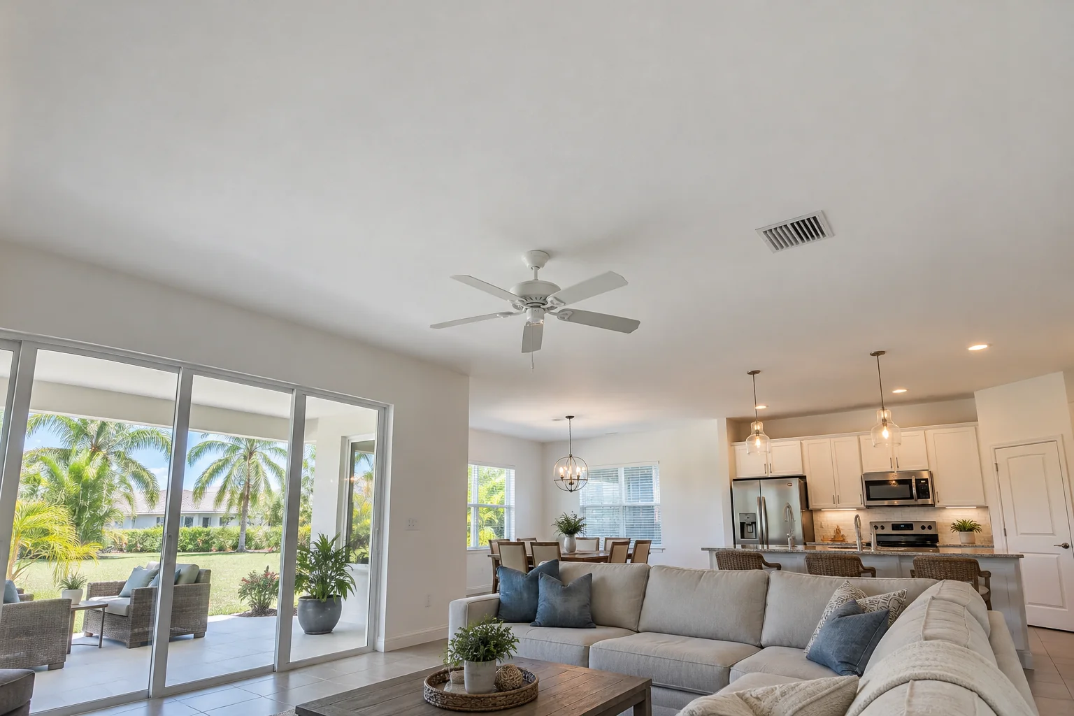 Smooth painted great room ceiling with a fan.
